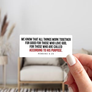 May include: A white rectangular sticker with black text that reads "WE KNOW THAT ALL THINGS WORK TOGETHER FOR GOOD FOR THOSE WHO LOVE GOD, FOR THOSE WHO ARE CALLED ACCORDING TO HIS PURPOSE. ROMANS 8:28." The words "ACCORDING TO HIS PURPOSE" are in red.