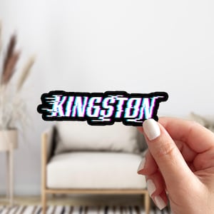 May include: A black and white sticker with the word "KINGSTON" in a glitched, pixelated font. The text is in blue and pink.