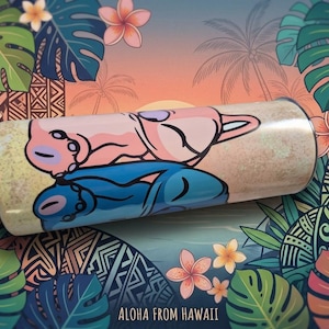May include: A cylindrical tumbler with a cartoon illustration of two characters in pink and blue, set against a tropical background with palm trees and flowers. The text "Aloha From Hawaii" is at the bottom.