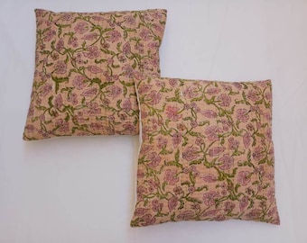May include: Two pink and green floral patterned throw pillows with white trim.