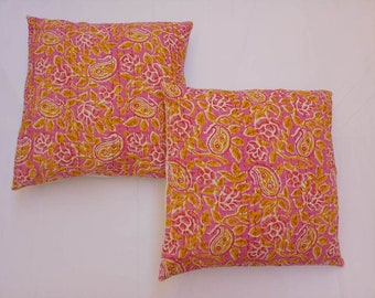 May include: Two pink and yellow patterned throw pillows with a floral and paisley design.