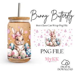 Op de afbeelding: Een 473 ml glazen blikverpakking PNG-bestand met een roze konijn met vlinder vleugels zittend op een nest van paaseieren. Het ontwerp bevat roze bloemen en vlinders op een witte achtergrond. De tekst "Bunny Butterfly" en "PNG FILE" zijn ook in het ontwerp opgenomen.