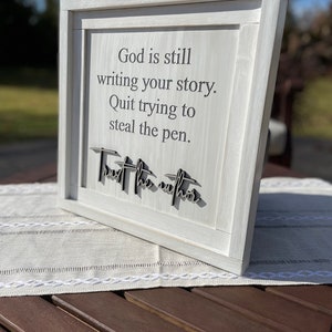 God is still writing your story sign. Quit Trying To Steal The Pen. Trust The Author. Religious and motivational.