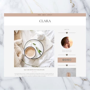 May include: A close-up of a cup of coffee on a white surface with a small plant and a white blanket. The text "QUI ARCHITECTO VOLUPTATE" is below the image.