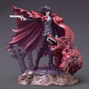 Op de afbeelding: Gedetailleerd beeldje van een personage uit "Hellsing" met lang zwart haar, een rode cape en een zwart pak, met een pistool. De figuur staat met een grommende, rode, veelkoppige hond. Een grafsteen en schedels staan aan de basis.