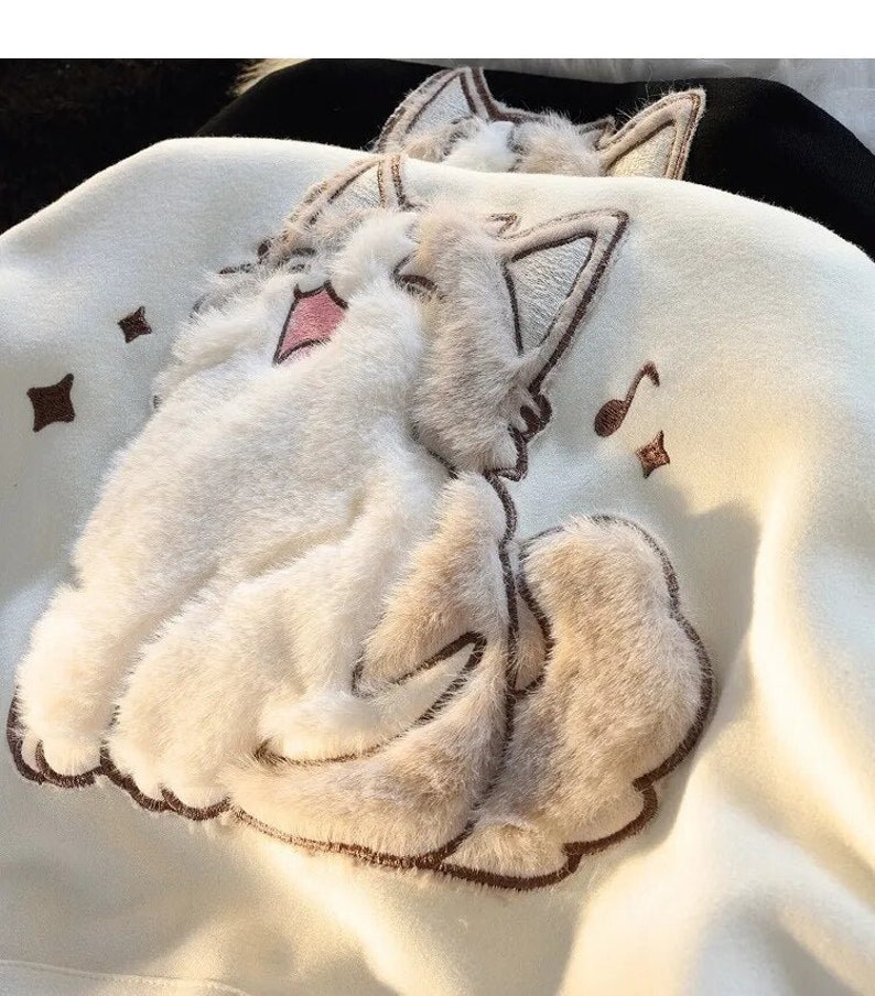 Close-up of singing cat and music note details on hoodie