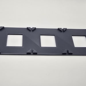 May include: A dark gray plastic frame with five rectangular openings. The frame is designed to hold five photos or other items.