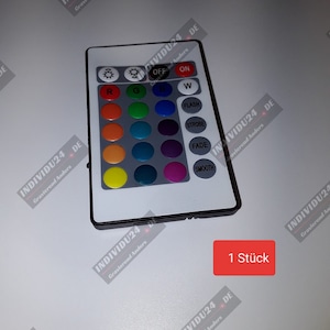 Könnte beinhalten: Eine weiße Fernbedienung mit 16 runden Tasten, die mit Farben und Lichtmodi beschriftet sind. Die Tasten sind in einem Raster angeordnet. Die Fernbedienung hat einen schwarzen Rand und einen schwarzen Knopf mit der Aufschrift "ON". Der Text "1 Stück" ist in Rot auf weißem Hintergrund gedruckt.