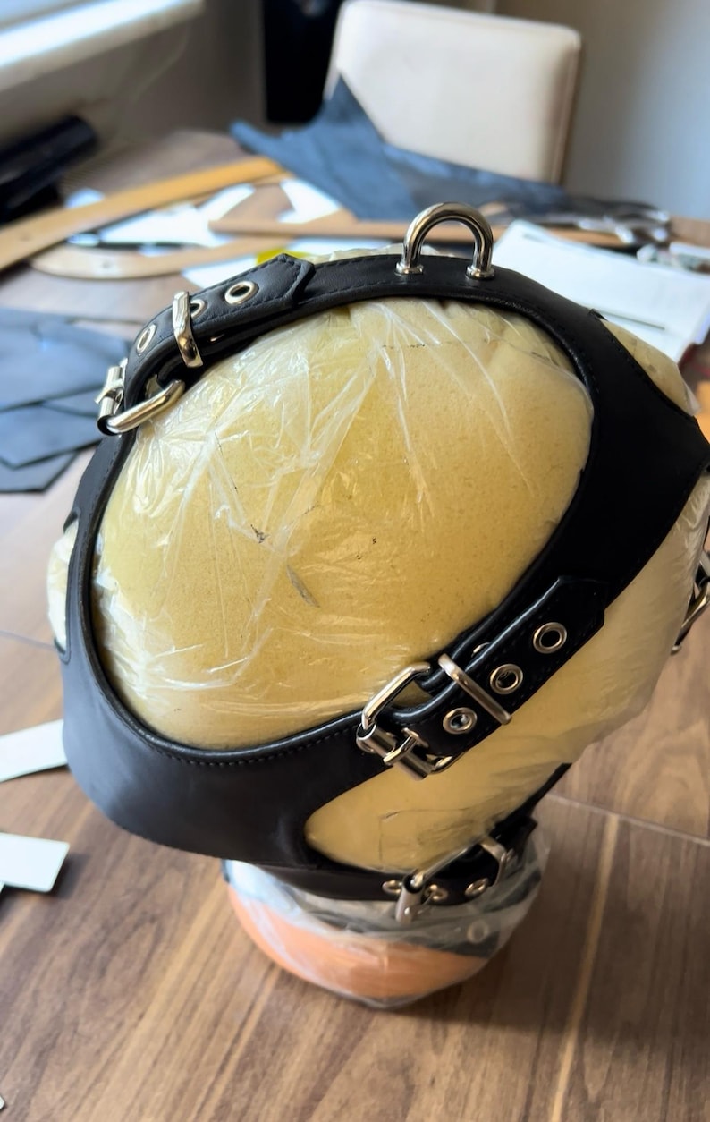 May include: Black leather head harness with silver buckles and rings. The harness is on a foam head form.
