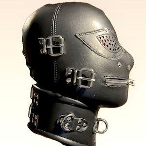 May include: Black leather hood with a zip mouth closure and a perforated eye shield. The hood features metal buckles and a neck collar with a D-ring.