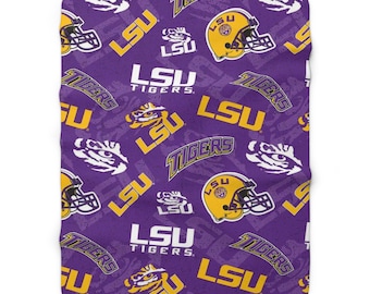 May include: Purple fleece blanket with a repeating pattern of the LSU Tigers logo, including the words "LSU Tigers" and a tiger paw print.