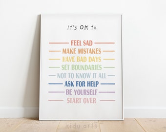 Puede incluir: Un póster enmarcado blanco con el texto "It's ok to" en negro. El póster enumera una serie de frases en colores arcoíris, incluyendo "Feel Sad", "Make Mistakes", "Have Bad Days", "Set Boundaries", "Not to Know It All", "Ask for Help", "Be Yourself", y "Start Over".