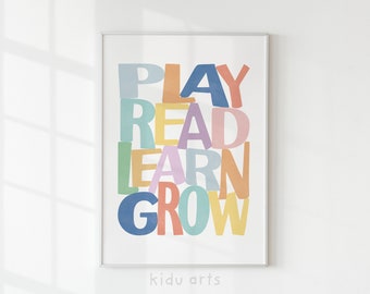 Könnte beinhalten: Ein farbenfroher Druck mit den Worten "PLAY READ LEARN GROW" in einem verspielten, übereinanderliegenden Schriftstil. Der Druck ist in einem weißen Rahmen gerahmt und trägt die Worte "kidu arts" unter dem Bild.