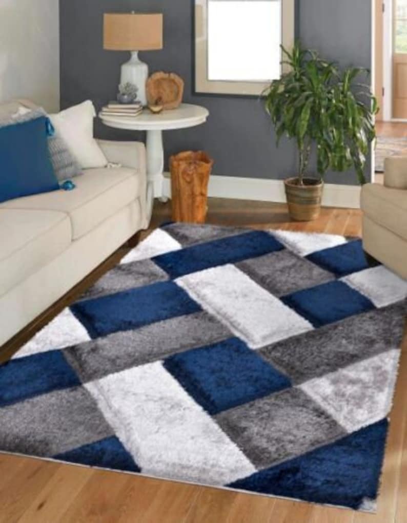 May include: A blue and gray area rug with a geometric pattern. The rug has a soft, plush texture and is perfect for adding a touch of modern style to any room.