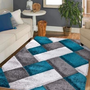 May include: A teal, gray, and white area rug with a geometric pattern. The rug has a soft, plush texture.