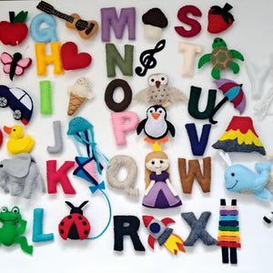 May include: A collection of colorful felt alphabet letters and accompanying felt objects, including a car, duck, butterfly, and ice cream cone. Each letter is paired with a corresponding object, creating a fun and educational display.