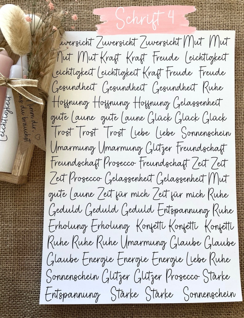 May include: A white card with black handwritten text. The text is in German and includes words like "Zuversicht", "Mut", "Kraft", "Freude", "Leichtigkeit", "Gesundheit", "Hoffnung", "Liebe", "Sonnenschein", "Umarmung", "Glitzer", "Freundschaft", "Prosecco", "Zeit", "Ruhe", "Geduld", "Entspannung", "Erholung", "Konfetti", "Glaube", "Energie", "St&auml;rke".