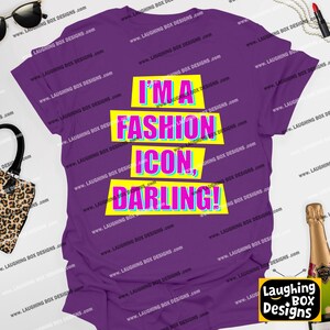 May include: A purple t-shirt with the text "I'M A FASHION ICON, DARLING!" in a vibrant, multi-colored design. The text is layered on top of yellow rectangles. The shirt is from Laughing Box Designs.