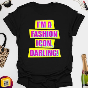 May include: Black t-shirt with a yellow and pink graphic that says "I'm a fashion icon, darling!"