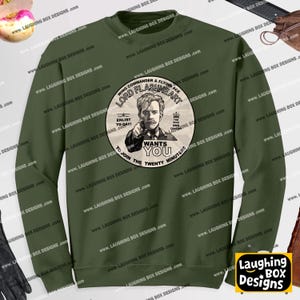 Peut inclure: Un sweat-shirt à col rond vert olive avec un motif circulaire sur la poitrine. Le motif représente un homme en uniforme militaire pointant vers l'avant avec le texte : Lord Flashheart, Wing Commander & Flying Ace, Enlist Today, Wants You.