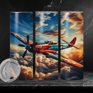 Könnte beinhalten: Ein rotes, blaues und weißes Flugzeug fliegt durch die Wolken vor einem Sonnenuntergangshimmel. Das Flugzeug hat eine große Propeller und fliegt niedrig über dem Boden. Die Wolken sind flauschig und weiß, und der Himmel ist in leuchtendem Orange und Gelb.