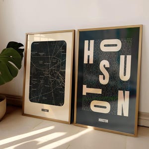May include: Two framed prints with gold frames. The print on the left is a black and white map of Houston, Texas. The print on the right is a black background with the word "HOUSTON" in white letters, with the letters made up of smaller text.