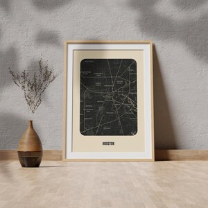Peut inclure: Une carte de Houston, Texas, en noir et blanc, encadr&eacute;e, avec un fond beige et le mot "HOUSTON" imprim&eacute; en noir en bas. Le cadre est en bois clair.