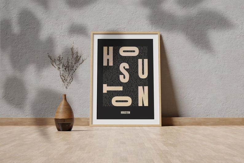 Peut inclure: Une impression encadr&eacute;e avec un fond noir et le mot "HOUSTON" &eacute;crit en grandes lettres beiges. Les lettres sont compos&eacute;es de texte plus petit, cr&eacute;ant un design typographique unique.
