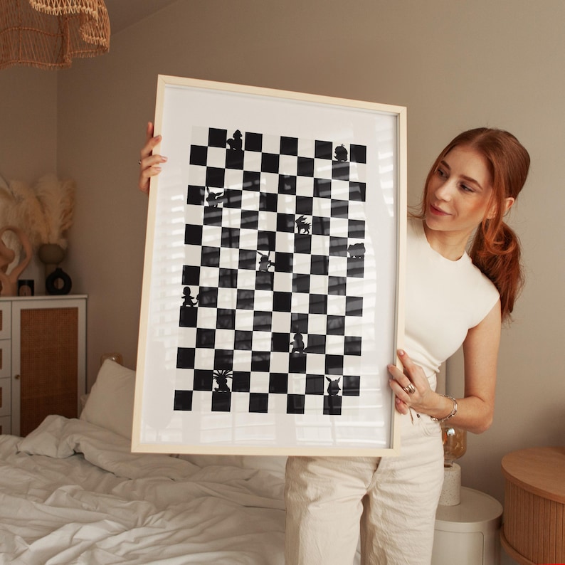 May include: Black and white framed artwork featuring a chess board design. The artwork has a light wood frame and a black and white checkered pattern. The chess pieces are represented by silhouettes.