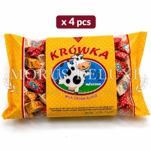 May include: A 1 kg package of Morus Deluxe Krówka milk cream fudge candies. The yellow plastic bag features a cartoon cow illustration, the text x 4 pcs, and a net weight of 1 kg. The individual candies are wrapped in colourful patterned foil.