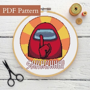 Puede incluir: Un patrón de punto de cruz en un aro de madera con un personaje rojo con un dedo en los labios, sobre un fondo de rayos de sol amarillos y naranjas. La palabra "SHHHHHHH!" está bordada debajo. El texto "PDF Pattern" está en la parte superior.