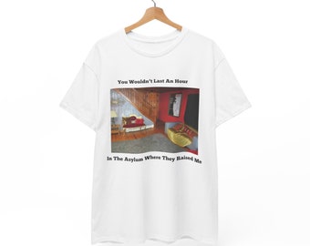May include: White t-shirt with a black and white image of a room with a couch and a staircase. The text "You Wouldn't Last An Hour In The Asylum Where They Raised Me" is printed on the shirt.