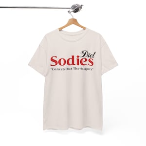 Może przedstawiać: Biały T-shirt z czerwono-czarną grafiką z napisem "Diet Sodies" i "Cancels Out The Sugars".