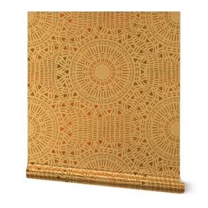 May include: A roll of wallpaper featuring a repeating circular pattern in shades of gold and orange. The design includes lines and triangles, creating a textured, geometric aesthetic. The wallpaper is partially unrolled, revealing the pattern.