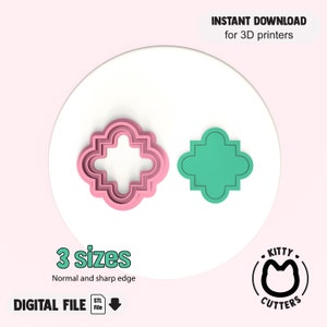 Op de afbeelding: Twee koekjessnijders in een vierpasvorm, één roze en één teal, op een wit oppervlak. Tekst luidt "INSTANT DOWNLOAD voor 3D-printers", "3 maten" en "DIGITAAL BESTAND". Er is ook een logo met een kattengezicht aanwezig.