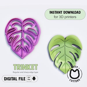 May include: Two 3D printed cookie cutters in the shape of a monstera leaf. The cutter on the left is purple and the cutter on the right is green. The text "INSTANT DOWNLOAD for 3D printers" is in a green rectangle at the top of the image. The text "TRINKET Regular and sharp edge type" is below the cutters. The text "DIGITAL FILE STL File" is below the previous text. The text "KITTY CUTTERS" is in a circle below the green cutter.