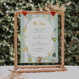 Puede incluir: Un menú de bar con marco de cobre con un fondo a rayas azul claro y blanco. El menú presenta el texto "The Bar" y enumera bebidas especiales, vino, cerveza y bebidas sin alcohol. Ilustraciones de acuarela de bebidas y guarniciones decoran los bordes.