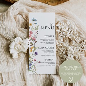 Peut inclure: Une carte de menu de mariage avec un motif floral. Le menu comprend des options d'entr&eacute;e, de plat principal et de dessert. Le texte indique "the MENU", "STARTER", "GARDEN SALAD OF BABY GREENS & BALSAMIC VINAIGRETTE", "JUMBO CRAB CAKE SERVED WITH REMUOLADE SOUCE", "MAIN COURSE", "FILET OF BEEF TENDERLOIN & GARLIC MASHED POTATOES SEASONAL VEGETABLES WITH SHERRIED MUSHROOM SAUCE", "DESSERT", "WEDDING CAKE WITH RASPBERRY BUTTERCREAM", "LIME PIE SERVED WITH WHIPPED CREAM", "MATCHING ITEMS AVAILABLE!", "SEE THE LISTING DESCRIPTION BELOW FOR THE DETAILS."