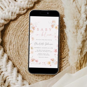 May include: A digital invitation for a baby shower with a floral design. The text reads "Baby in Bloom" and includes the name "Charlotte Johnson" and the date "Saturday, August 18, 6 PM".