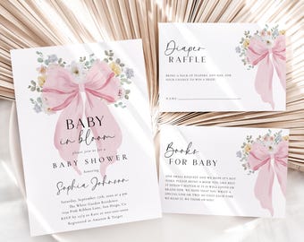 Puede incluir: Invitación a una baby shower con un lazo rosa y un diseño floral. La invitación dice "Baby in Bloom" e incluye la fecha, la hora y el lugar de la ducha. También incluye una solicitud para que los invitados traigan pañales o libros para el bebé.