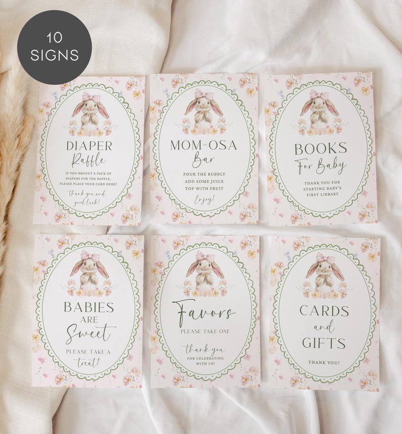 May include: A set of six baby shower signs with a bunny theme. Each sign has a floral border and a watercolor illustration of a bunny. The signs include text such as "Diaper Raffle" and "Mom-osa Bar".