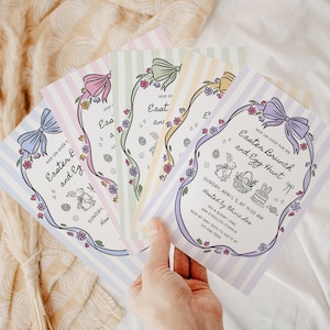 Op de afbeelding: Een set van drie keramische mokken met een gespikkelde, crèmekleurige glazuur. Elke mok heeft een handgeschilderd ontwerp: een blauw en groen blad, een gele bloem en een rode bes. De mokken hebben een eenvoudige, afgeronde vorm.