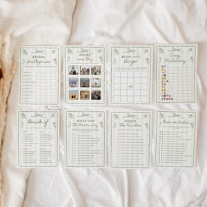 K&ouml;nnte beinhalten: Eine Sammlung von acht gr&uuml;nen und wei&szlig;en Spielkarten f&uuml;r eine Brautparty. Jede Karte zeigt ein anderes Spiel, darunter "Bridal Scattergories", "Where were they" und "Bridal Gift Bingo". Die Karten haben einen gewellten Rand und dekorative florale Elemente.