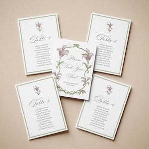 May include: A collection of wedding stationery, including table cards and a central sign. The cards feature elegant calligraphy, floral accents, and guest names. The central sign reads "Please Find Your Seat" with the couple's names and date.