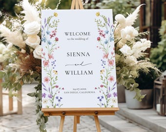 May include: A wooden easel displays a white sign with floral accents and the text "Welcome to the wedding of Sienna and William." The sign includes the date and location, San Diego, California.