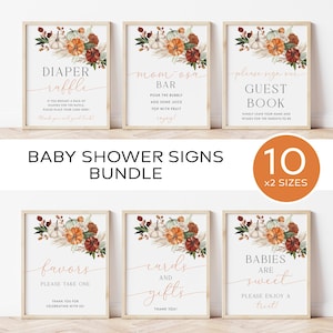 May include: Ten printable baby shower signs with a fall theme. The signs feature a floral arrangement with pumpkins, leaves, and wheat stalks in shades of orange, brown, and white. The signs have text that reads "Diaper Raffle", "Mom-osa Bar", "Please Sign Our Guest Book", "Favors", "Cards and Gifts", and "Babies Are Sweet".