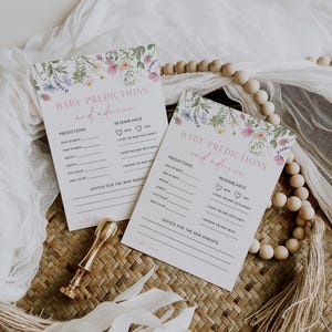 K&ouml;nnte beinhalten: Zwei wei&szlig;e Karten mit floralen R&auml;ndern und dem Text "Baby-Vorhersagen und Ratschl&auml;ge" darauf gedruckt. Die Karten haben Linien, auf denen die G&auml;ste ihre Vorhersagen f&uuml;r das Geburtsdatum, die Uhrzeit, das Gewicht, die L&auml;nge, die Augenfarbe, die Haarfarbe und die &Auml;hnlichkeit mit den Eltern des Babys eintragen k&ouml;nnen. Die Karten haben auch einen Platz f&uuml;r die G&auml;ste, um Ratschl&auml;ge f&uuml;r die neuen Eltern zu schreiben.