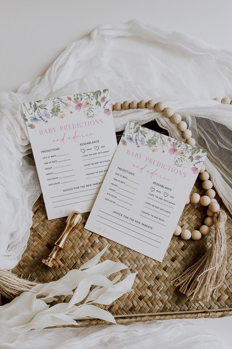 K&ouml;nnte beinhalten: Zwei wei&szlig;e Karten mit floralen R&auml;ndern und dem Text "Baby-Vorhersagen und Ratschl&auml;ge" darauf gedruckt. Die Karten haben Linien, auf denen die G&auml;ste ihre Vorhersagen f&uuml;r das Geburtsdatum, die Uhrzeit, das Gewicht, die L&auml;nge, die Augenfarbe, die Haarfarbe und die &Auml;hnlichkeit mit den Eltern des Babys eintragen k&ouml;nnen. Die Karten haben auch einen Platz f&uuml;r die G&auml;ste, um Ratschl&auml;ge f&uuml;r die neuen Eltern zu schreiben.