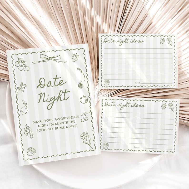 K&ouml;nnte beinhalten: Ein Set mit Ideen f&uuml;r einen romantischen Abend, mit einem gr&uuml;n-wei&szlig; gestreiften Design. Die Karten zeigen den Text "Date Night" und "Date night ideas" mit dekorativen Fruchtdarstellungen. Das Set enth&auml;lt eine gr&ouml;&szlig;ere Karte und zwei kleinere Karten.