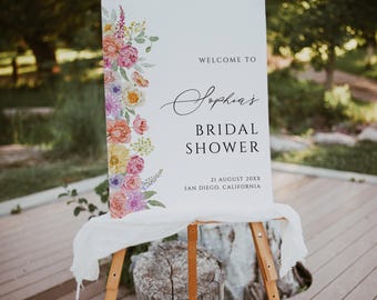 Può includere: Un cartello di benvenuto bianco con un design floreale in tonalità rosa, giallo e viola. Il cartello recita "Benvenuti a Sophia's Bridal Shower, 21 agosto 20XX, San Diego, California."